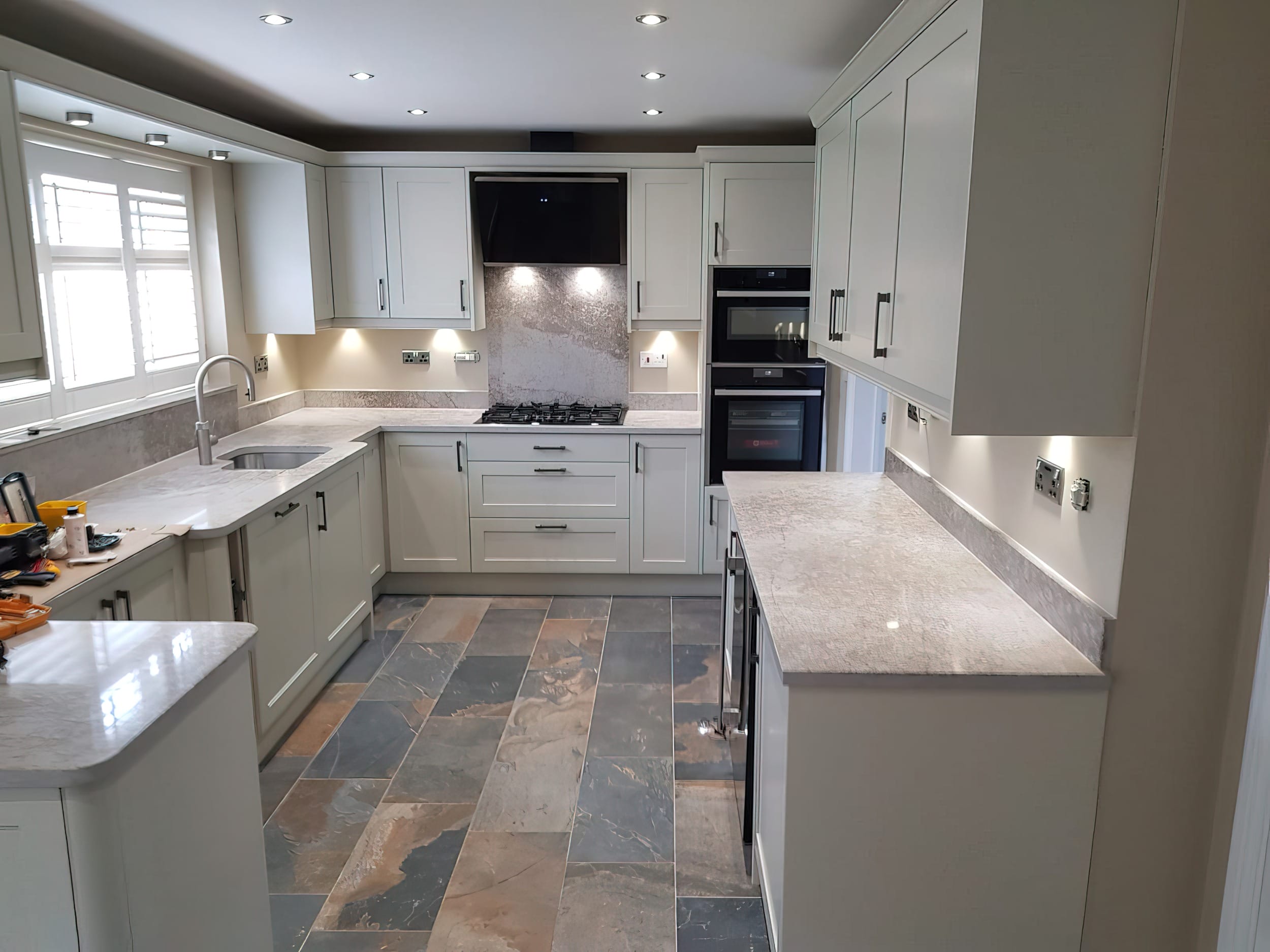 Bespoke fitted kitchen installation in Wirral featuring shaker-style units, quartz worktops and integrated appliances by Mastercraft Kitchens.