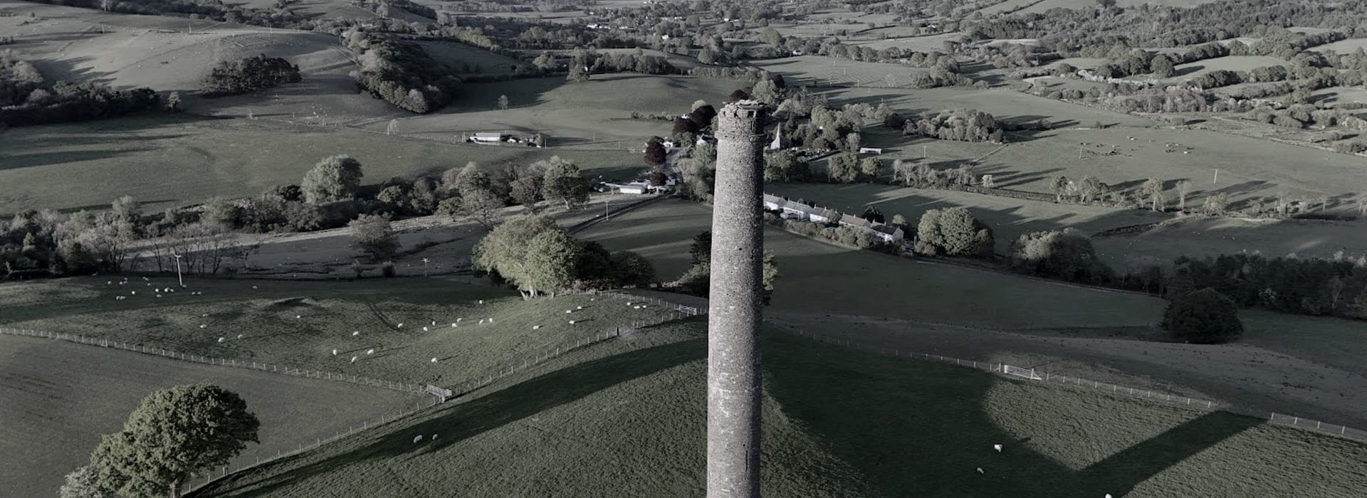 Bespoke Kitchens Lampeter - Mastercraft Kitchens tall stone tower rising from green rolling countryside with scattered sheep